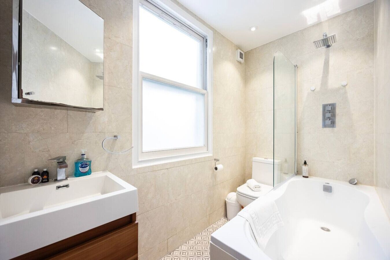 A modern bathroom with a large bathtub, a separate shower area, and a window providing natural light.