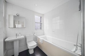 A bathroom with a toilet, sink, and bathtub. - 2-BR in the Heart of Soho - 5 guests (Greater London)