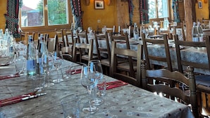 Un restaurante con interiores de madera, candelabros de encaje y mesas dispuestas para comer.