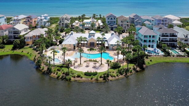 A resort with a central pool, surrounding villas, and a view of the ocean. - Newly remodeled top floor gem in Cinnamon Beach condo 1062! (Palm Coast)