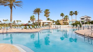 A swimming pool with lounge chairs and palm trees. - Newly remodeled top floor gem in Cinnamon Beach condo 1062! (Palm Coast)