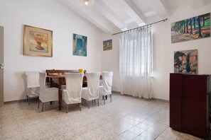 Un'area pranzo con tavolo, sedie e opere d'arte alle pareti.
