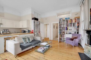 A living room with a sofa, coffee table, and a bookshelf. - 1 Bedroom Apartment in Central Soho - 4 people (Greater London)