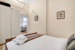 Een hotelkamer met een bed, een kledingkast en uitzicht op de gang.