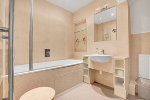 A modern bathroom with a glass shower enclosure, a white sink, and a mirror above the sink. - 1 Bedroom Apartment in Central Soho - 4 people (Greater London)
