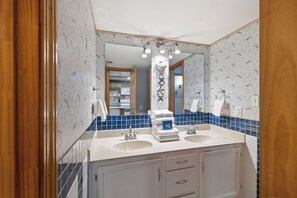 Ein Badezimmer mit zwei Waschbecken, einem Spiegel und einem Handtuchhalter.