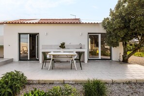 A modern house with a kitchen, dining area, and a tree. - Refugio del Laurel, Sesimbra (Sesimbra)