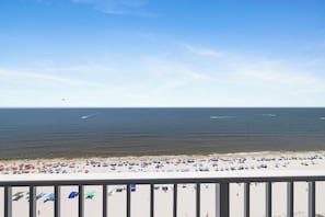 A beach with numerous umbrellas and people. - Lighthouse 1505 by Liquid Life (Gulf Shores)
