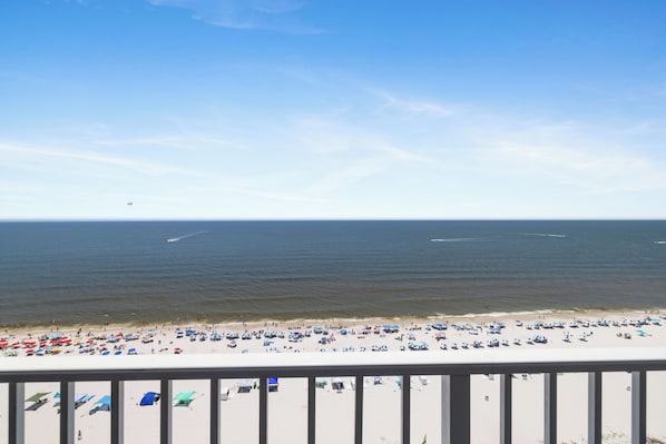 A beach with numerous umbrellas and people. - Lighthouse 1505 by Liquid Life (Gulf Shores)