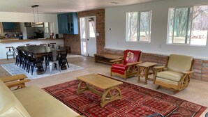 A spacious living area with a dining table, sofas, and a fireplace.