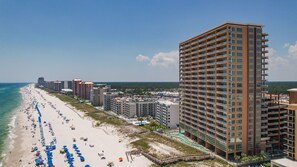 Ein Hotel direkt am Strand mit mehreren Etagen, einem Poolbereich und einem langen Sandstrand.