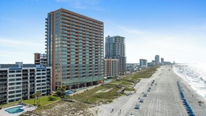 A beachfront hotel with multiple high-rise buildings, a sandy beach, and a clear sky. - Phoenix Orange Beach 1805 by Liquid Life (Orange Beach)