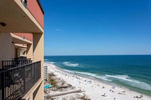 Ein Hotel direkt am Strand mit Balkonen, einem Sandstrand und dem Meer.