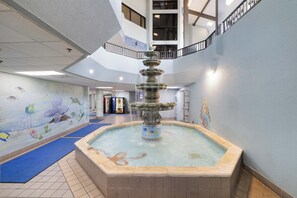 A multi-level indoor space with a central fountain, tiled flooring, and a mural with aquatic themes. - Phoenix V 505 by Liquid Life (Orange Beach)