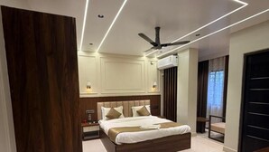 Ein modernes Schlafzimmer mit einem großen Bett, einem Deckenventilator und Einbauleuchten.