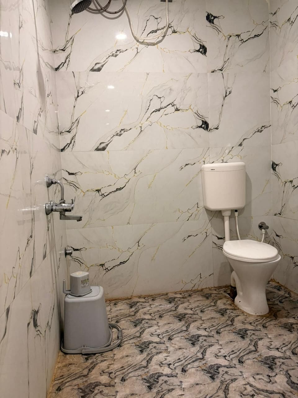 A bathroom with a toilet, a shower, and a bidet.