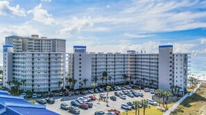 A multi-story hotel with a parking lot and beach view. - Seaside Beach & Racquet 2203 by Liquid Life (Orange Beach)