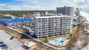 Ein mehrstöckiges Hotel mit Pool, Blick auf den Strand und mehreren Balkonen.