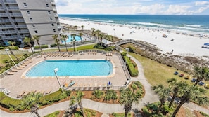 Ein Hotel mit Pool, Strandblick und Palmen.