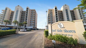 A multi-story hotel with a sign reading 'Surf Side Shores' at the entrance. - Surfside Shores 1803 by Liquid Life (Gulf Shores)