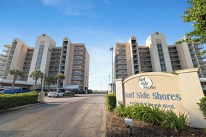 A multi-story hotel with a sign reading 'Surf Side Shores' at the entrance. - Surfside Shores 1803 by Liquid Life (Gulf Shores)