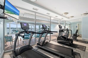 Un centre de remise en forme équipé de tapis de course, d’un vélo elliptique et d’un vélo d’appartement.
