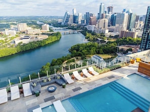 A rooftop pool with lounge chairs, a city skyline, and a river. - 3010 ATX Longhorn Penthouse | Rooftop Pool, Skyline & Rainey St Nightlife (Austin)