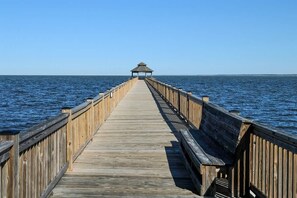 Eine Holzstege, der sich ins Wasser erstreckt, mit einem Pavillon am Ende.