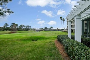 Ein Golfplatz mit Clubhaus, dessen modernes Design weiße Säulen und große Fenster aufweist.