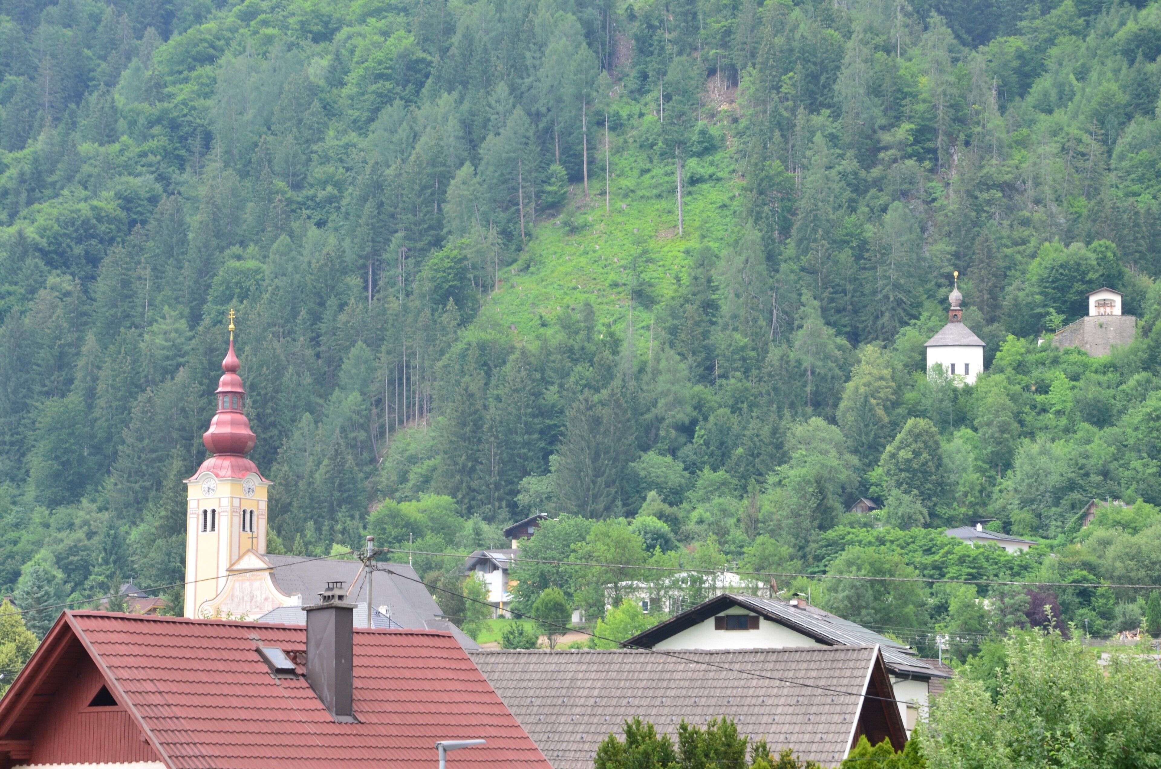A mountainous landscape with a church and residential buildings.