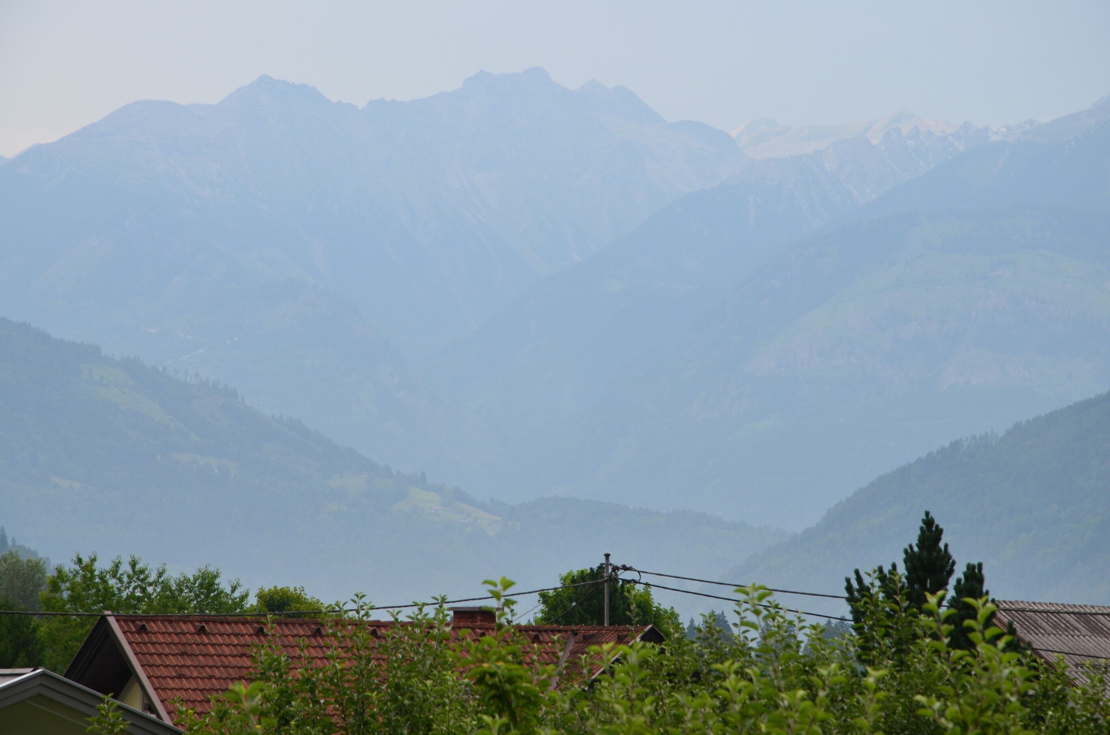 Un paysage de montagne avec une maison au premier plan.