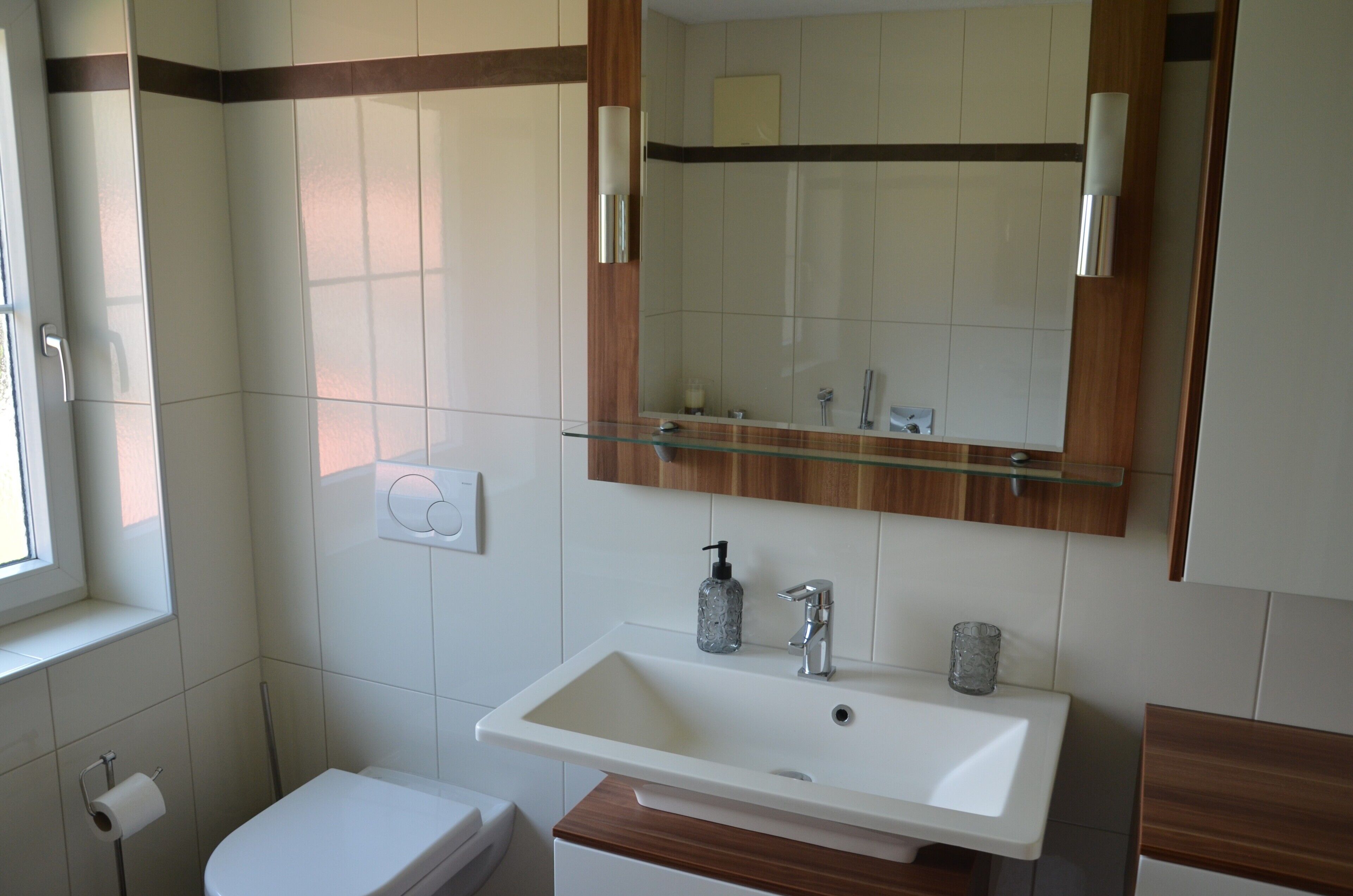 Ein Badezimmer mit Waschbecken, Spiegel und Toilette.