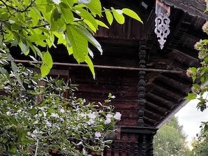 Ein traditionelles Holzgebäude mit Balkon und hängenden Verzierungen.