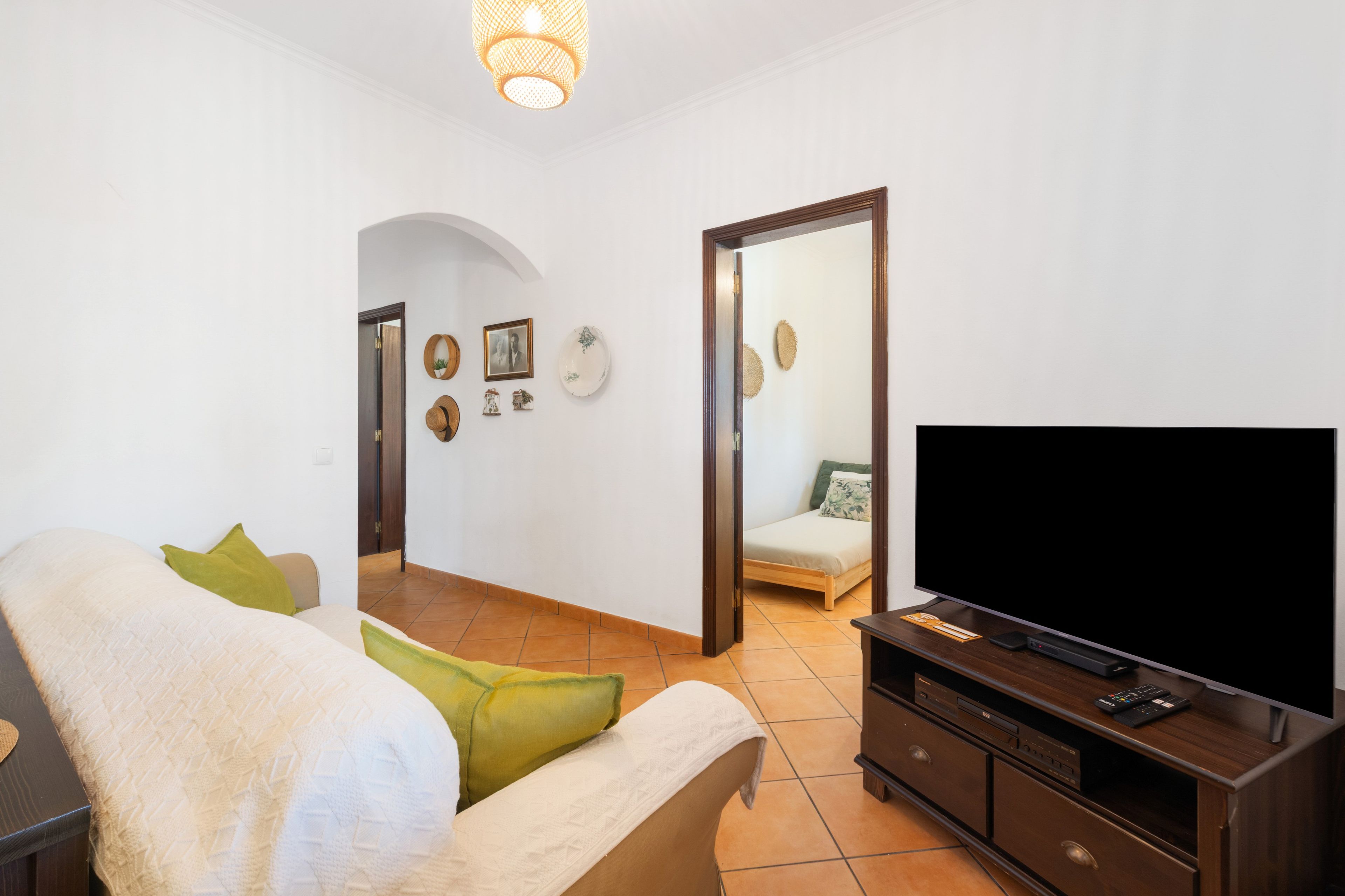 Ein Schlafzimmer mit einem Bett, einem Fernseher und einem Spiegel.