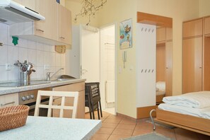 A compact room with a kitchenette, a bed, and a bathroom. - Geraumige Ferienwohnung im Seepark Sellin mit Wlan (Sellin)