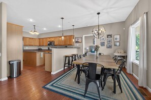 A spacious kitchen with wooden cabinets, a central island, and pendant lighting. - Lakefront Ozarks Home: Pool, Deck, View, Sleeps 26 (Camdenton)