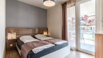Un dormitorio moderno con una cama grande, lámparas de noche y vistas al exterior.
