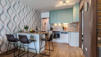 Eine moderne Küche mit einer zentralen Kochinsel, Barhocker und einer Wand mit Muster.