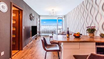 Een moderne keuken met een houten kookeiland, barkrukken en uitzicht naar buiten.