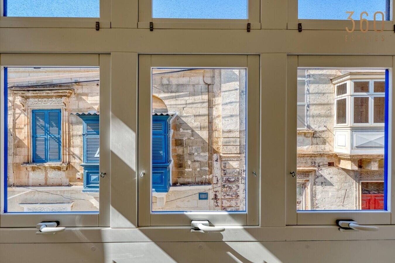 Un edificio con tre finestre, ognuna con vista su stili architettonici diversi.