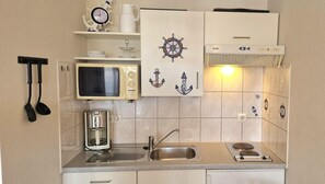 A compact kitchen with a microwave, coffee maker, and a sink. - Moderne Ferienwohnung mit Balkon Strandnah im Seepark Sellin (Sellin)