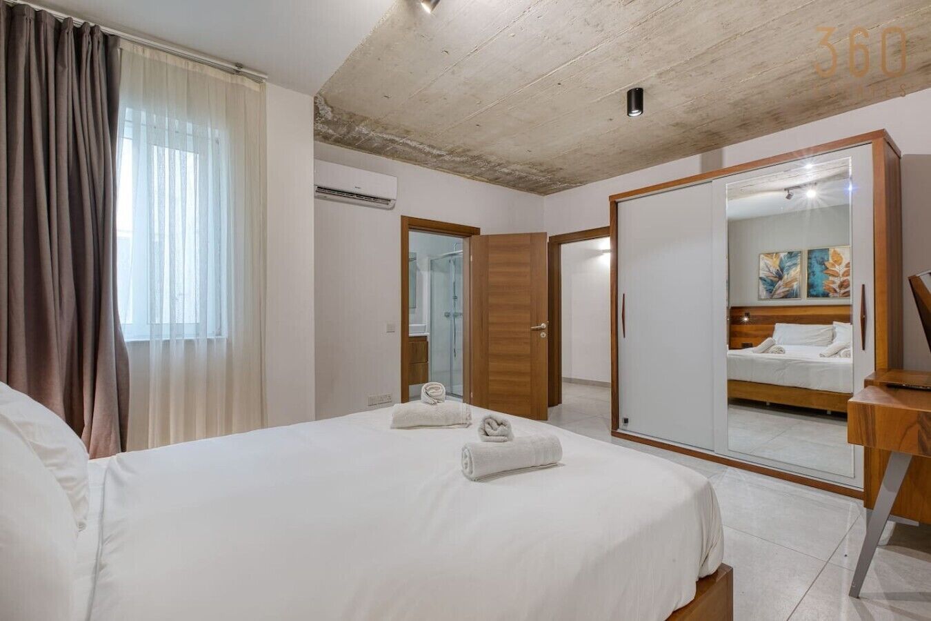 Une chambre d’hôtel comprenant un lit, un miroir, une armoire et un espace douche.