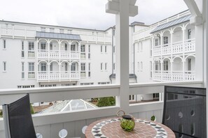 A balcony with a table, chairs, and a view of white buildings. - Komfortable Ferienwohnung fur Zwei in Sellin mit Balkon (Sellin)