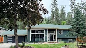 A two-story house with a green exterior, a front garage, and a well-maintained lawn. - Fernan Retreat 3BR Minutes to Downtown the Lake (Coeur d'Alene)
