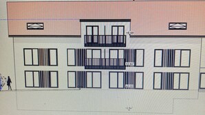 Ein Gebäude mit Flachdach, rechteckigen Fenstern und einem Balkon.