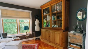 Ein Zimmer mit einem großen Holzschrank, einer Schönheitsmaske und einem Fenster mit Blick auf Grünflächen.