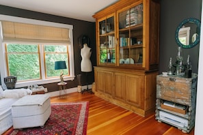 A room with a large wooden cabinet, a mannequin, and a window with a view of greenery. - Artsy Vineyard Escape w/ Deck & Guest Suite (Oak Bluffs)