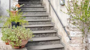 Una escalera que lleva a un edificio con una ventana y barandilla de metal.