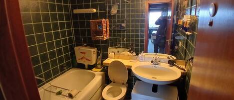 A bathroom with a bathtub, toilet, and sink.