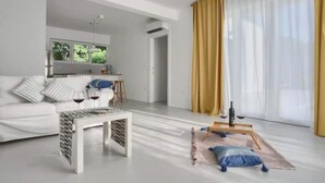 En moderne stue med sofa, sofabord og et spiseområde med bord og stole.